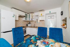 a kitchen with blue chairs and a table at Apartment Pavilion in Kampor