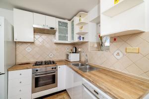 a kitchen with white cabinets and a sink at Apartment Pavilion in Kampor
