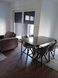 a living room with a table and chairs and a couch at Pristhine Stay Inn 21 in Prishtinë +12 photos