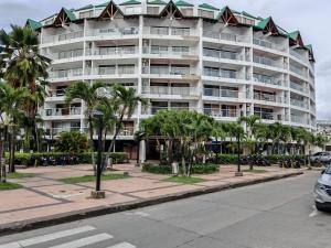 a large white building on a street with palm trees at EDIFICIO HANSA REEF - Apartamento 509 in San Andrés