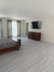 a large room with a bed and a flat screen tv at The Lofted Retreat in Newnan