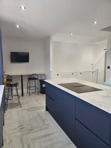 eine Küche mit blauen Schränken und einer Arbeitsplatte in der Unterkunft Luxury 3 bed next to city centre in Killingbeck