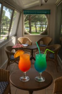 two colorful cocktails sitting on a table in a room at Bel appart vue lac in La Grande Motte