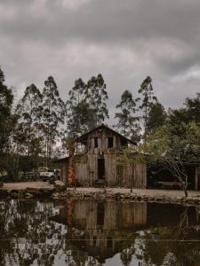 an old house next to a body of water at Lauro Muller, Rancho Queimado in Louro Müller