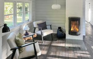 sala de estar con chimenea y 2 sillas en 2 Bedroom Lovely Home In Nykøbing Sj, en Nykøbing Sjælland