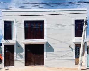 a white building with brown doors on it at Hotel Casa Nudo, Chukum, Mérida in Mérida