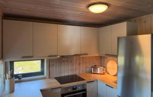 a kitchen with white cabinets and a stainless steel refrigerator at 2 Bedroom Beautiful Home In Gålå in Gålå