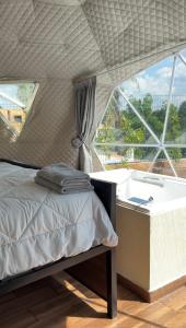 un dormitorio con una cama y una bañera en Luahara Glamping Domo Experience Presa de las Tortugas - Huaxtla Zapopan, 