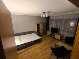 a small bedroom with a bed and a television at Mieszkanie 41 in Częstochowa