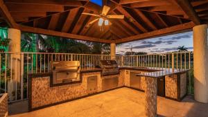 a screened in porch with a table and a grill at Plantation Luxe Villa 9BR Private Resort in Plantation Acres