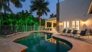 a swimming pool with chairs and a house at Plantation Luxe Villa 9BR Private Resort in Plantation Acres