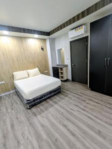a bedroom with a white bed in a room at ICHA Apartments in Suva