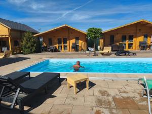 a man is swimming in a swimming pool at Perła Brenno in Brenno