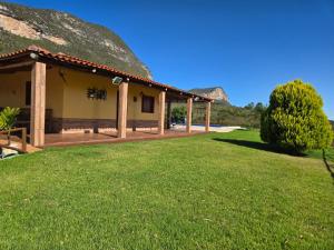 a house with a thatched roof and a grass yard at Casa de Campo Ibicoara in Ibicoara