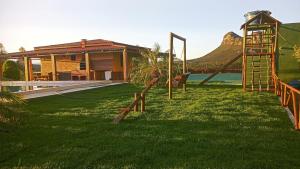 a playground in front of a house with a mountain at Casa de Campo Ibicoara in Ibicoara
