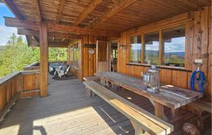a porch of a wooden cabin with benches and windows at Awesome Home In Eggedal With Sauna in Eggedal +25 photos