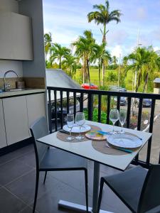 een witte tafel met wijnglazen op een balkon bij Studio Marina Blue in Saint-François