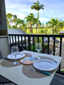een tafel met twee borden en glazen op een balkon bij Studio Marina Blue in Saint-François
