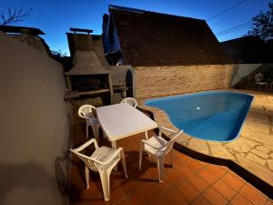 a patio with a table and chairs and a swimming pool at La casa de Lolo in San Antonio de Areco