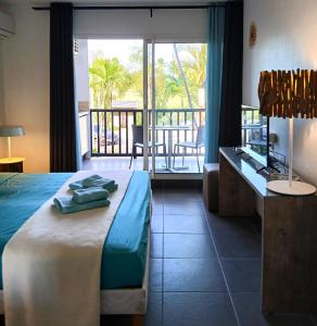 een slaapkamer met een bed en een bureau en een balkon bij Studio Marina Blue in Saint-François