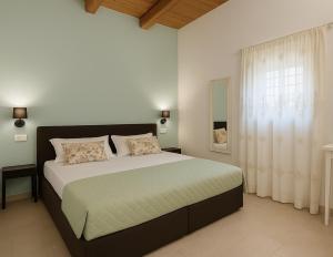 een slaapkamer met een groot bed en een raam bij Torre Dantona Country Suites in Pozzallo +152 foto's