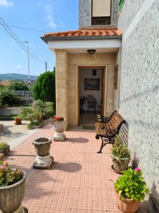 eine Bank, die auf einem steinernen Gehweg neben einem Gebäude sitzt in der Unterkunft Gran casa rural con Finca de 4000 m2 in Quijano