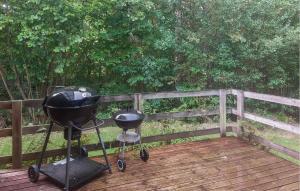 a grill and smoker sitting on a wooden deck at 2 Bedroom Amazing Home In Örkelljunga in Åsljunga