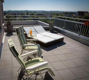 eine Terrasse mit 2 Stühlen und einem Tisch auf dem Balkon in der Unterkunft En attique - Residence le Ronsard in Sélestat