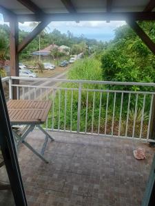 a balcony with a bench and a view of a street at Appartement le carbet in Capesterre-Belle-Eau