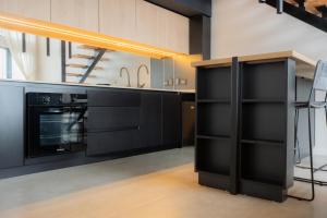 a kitchen with black cabinets and a stove at Studios del Susana - Dúplex Únicos y Exclusivos in Ushuaia +21 photos