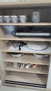 a refrigerator drawer filled with dishes and a microwave at Waterfront apartment with a breathtaking view in Sharjah