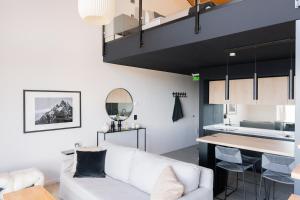 a living room with a white couch and a table at Studios del Susana - Dúplex Únicos y Exclusivos in Ushuaia