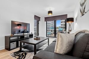 リバプールにあるCentral Liverpool Luxury 2BR w Balcony & 2 Bathsのソファとテレビのあるリビングルーム