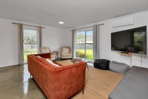 a living room with a couch and a flat screen tv at Ruakaka Coastal Reserve Retreat in Ruakaka