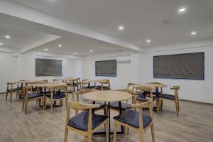 a classroom with tables and chairs and a projection screen at Super Townhouse Hadapsar in Pune