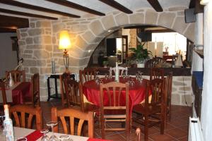 um restaurante com uma mesa e cadeiras e uma parede de pedra em Fonda Angeleta em Valderrobres