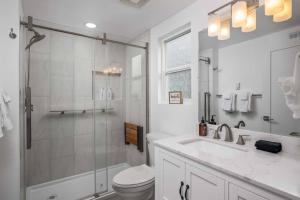 a bathroom with a shower and a toilet and a sink at Beachfront Family Sanctuary in Rockaway Beach +42 photos