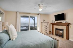 a bedroom with a bed with a fireplace and a television at Beachfront Family Sanctuary in Rockaway Beach
