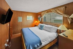 Un dormitorio pequeño con una cama y una ventana. en Ocean's Edge Escape, en Twin Rocks
