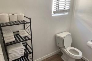 a white bathroom with a toilet and towels at Sea Haven Motel Unit #4 in Rockaway Beach