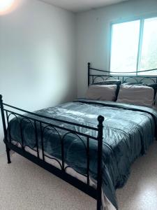 ein schwarzes Bett in einem Zimmer mit Fenster in der Unterkunft West end in Edmonton