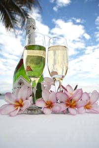 two glasses of white wine and flowers on a table at Lake Kariba Inns in Siavonga