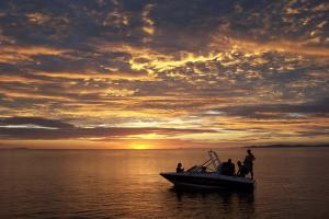 a group of people on a boat in the water at sunset at Lake Kariba Inns in Siavonga