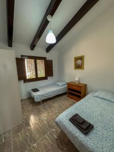 a room with two beds and a table in it at Casa rural Benthomiz 210, Algarrobo, Málaga, España in Algarrobo