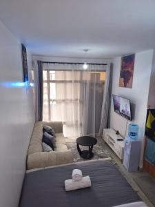 una sala de estar con una cama y un sofá en Studio Apartments at Tsavo Royal Surburbs,Roysambu, en Nairobi