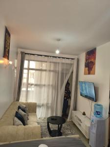 Una sala de estar con un sofá y una ventana. en Studio Apartments at Tsavo Royal Surburbs,Roysambu, en Nairobi