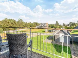 a balcony with chairs and a view of a yard at 5 star holiday home in Rømø in Sønderby