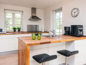 a kitchen with a wooden counter with two stools at Panoramic Golf View Retreat - By Traum Ferienwohnungen in Sønderby