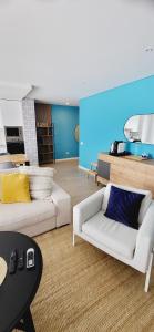 a living room with two white couches and a blue wall at Marco Polo Apartment in Nazaré