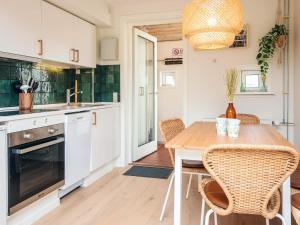 a kitchen with a wooden table with chairs and a dining room at 6 person holiday home in Rømø in Sønderby